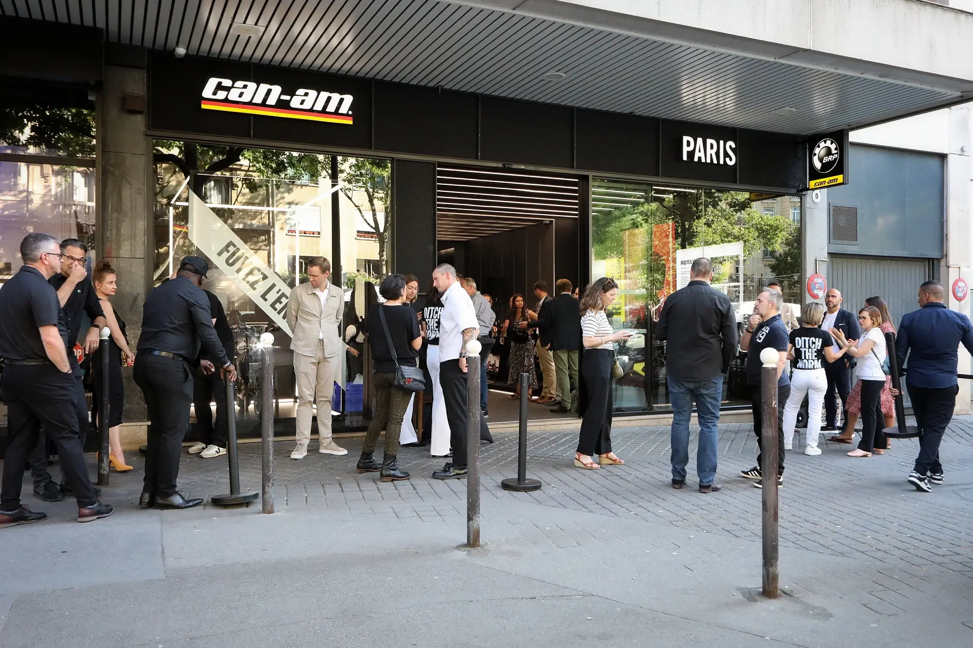 Devanture du flagship store Can-Am à Paris avec un groupe de personnes discutant à l'extérieur